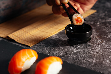 eat sushi with soja sauce with chopsticks