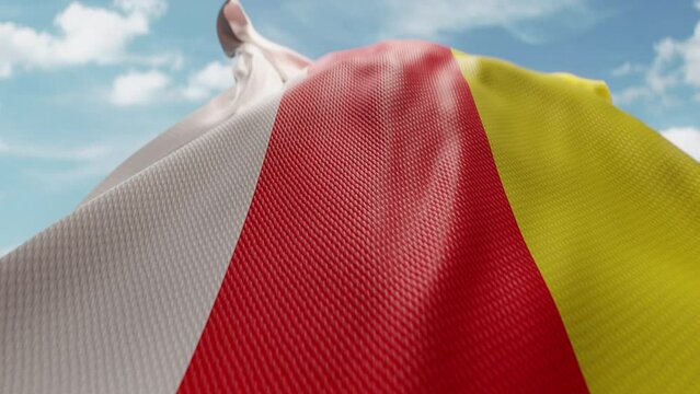 Wavy flag of South Ossetia blowing in the wind in slow motion. Waving official Ossetian flag team symbol abstract vertical background. Blue sky with clouds. World countries flying flags concept