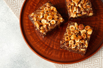 Brownie cake with nuts topping on plate close up