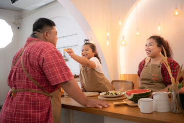 A plus-size family with a father wearing a prosthetic leg, Eat together after cooking and daughter...