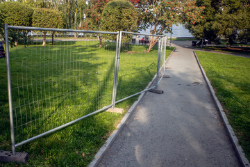 Mobile metal sidewalk fencing on an autumn day
