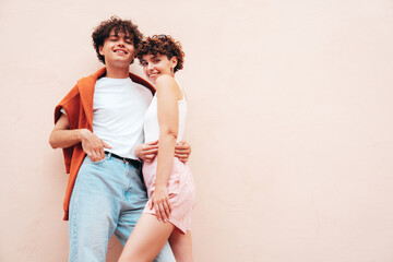 Young smiling beautiful woman and her handsome boyfriend in casual summer white t-shirt and jeans...