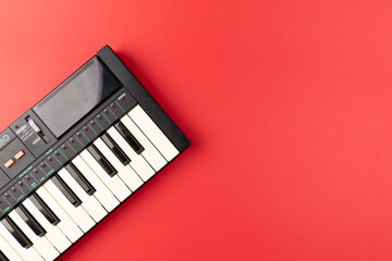 Vintage electronic keyboard synth piano on red background
