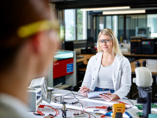 Smiling scientists working on workbench in laboratory