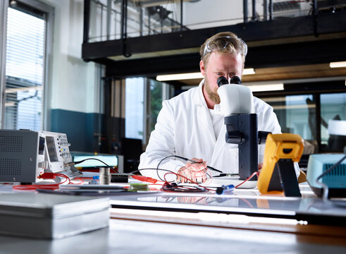 Scientist examining through microscope in laboratory