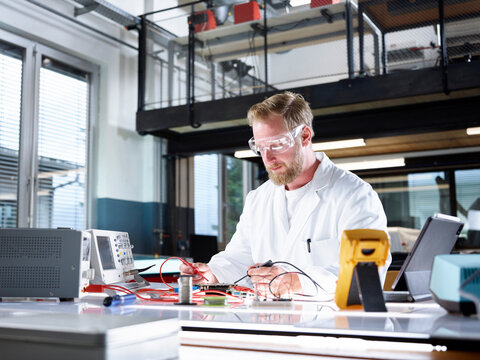 Scientist examining and working on electrometer in laboratory