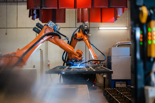 Industrial robotic arms welding in factory