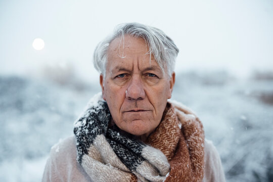 Senior man with gray hair in snow