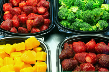 Frozen berries, fruits and vegetables in supermarket window, top view. Frozen food.