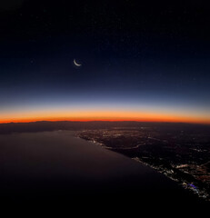 Naklejka na ściany i meble View of Antalya city and city lights from the plane at sunset