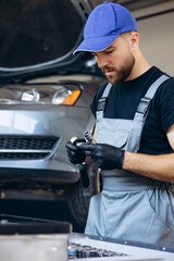 Auto mechanic using wrench and other tools on car service