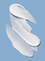 Cosmetic smear of cream texture on a blue background. Skin care.