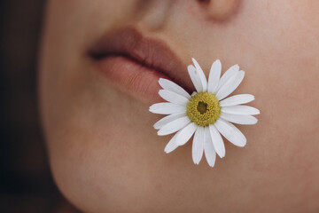 girl's face, daisy on the girl's lips