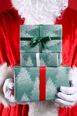 Gift boxes in Santa's hands on red background