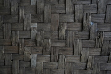 the texture of the woven old bamboo wall with a worn brown color that is worn with age
