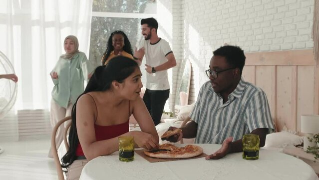 International couple african American man and Indian female talking and then arguing shouting during the party, spoiled fun evening. Misunderstanding between young man and woman. Break up. Divorce 