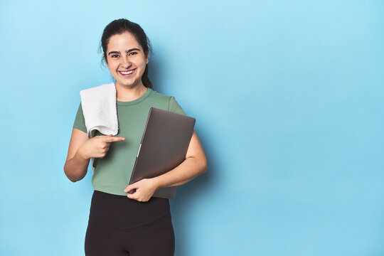 Athletic woman with a computer on a blue background