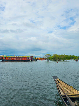Traditional baots with a houseboat at the Tanguar Haor in Sunamganj, a famous tourist spot in Bangladesh while it was raining during the monsoon season. Rivers of Bangladesh