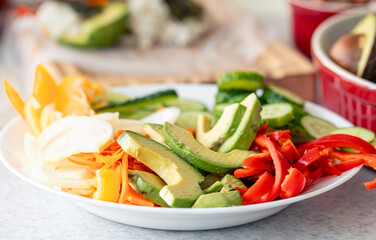 Close-up, plate with fresh chopped vegetables on the kitchen table.