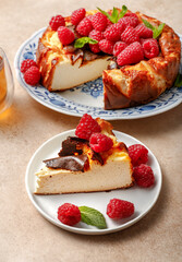 Cheesecake Saint Sebastian. Basque cheesecake. A piece of Spanish cheesecake with raspberries and mint on a beige background. Keto diet.