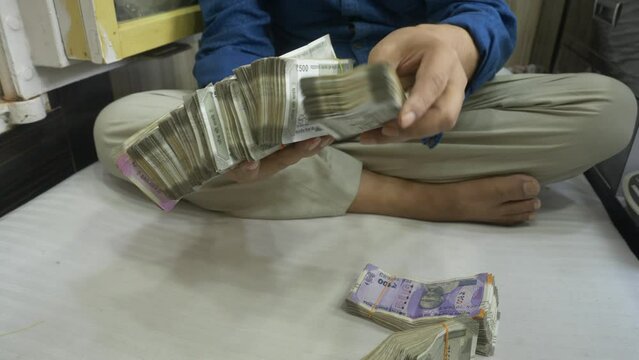 A businessman counting stack of Indian banknotes, Cash in hand, Lots of cash, Wide angle shot