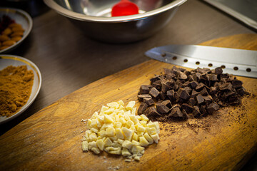 Woman cooking tasty melted chocolate on table in kitchen.