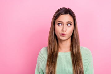 Fototapeta premium Portrait of cute think lady doubts pouted lips looking empty space uncertain suspicious look empty space isolated on pink color background