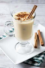 Homemade eggnog with cinnamon on wooden table. Typical Christmas dessert. Close up