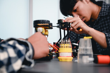 Engineer Asian Students Assembling Robotics Kits. Learning Mechanical Control, Robotics combines computer, electrical, mechanical, and sensing. Empowering Engineers and Development Concept.