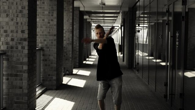 Young man in the hallway of a modern building. Looking at camera.