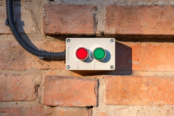 Power on and off buttons placed on a brick wall. Electrical equipment installation concept