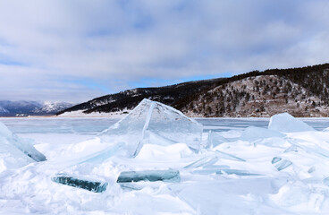 Winter landscape of snowy frozen Baikal Lake on a frosty January day. Ice hummocks with pieces of...