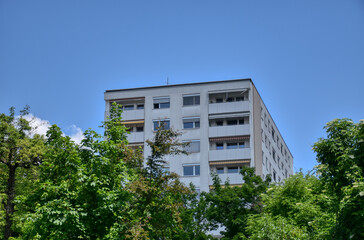 Wohnhaus, Hochhaus, Gebäude, 1970er, 1980er, 1990er, Stockwerk, Etage, Fenster, Balkon, Wohnviertel, Wohnungen, wohnen, Neubau, weiß, charakterlos, Stadt, gewöhnlich, Doppelfenster, Geländer, Gebüsch,