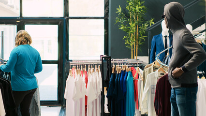 African american thief stole stylish clothes in clothing store, being caught by asian security...