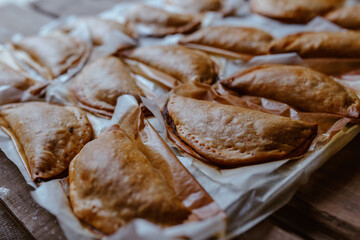 Baking tray with composed freshly baked pies patty