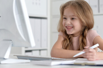 Cute and happy little girl children using laptop computer