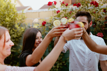 Obraz premium Group of cheerful friends clinking glasses at party