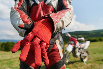 A professional motocross rider putting his gloves and preparing for a professional motocross ride © .shock