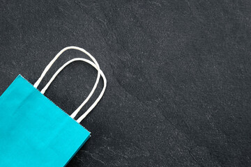 Paper shopping bag on a dark background, top view.