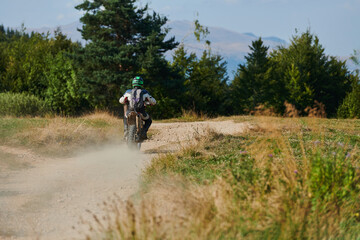 Naklejka premium A professional motocross rider exhilaratingly riding a treacherous off-road forest trail on their motorcycle.