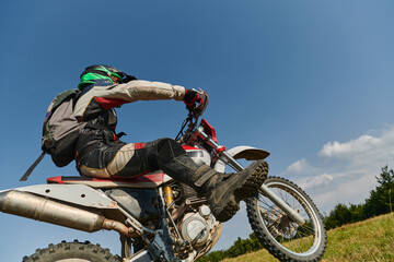 A fearless professional motocross rider skillfully executes an extreme back wheelie maneuver...