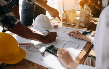 Two colleagues discussing data working and tablet, laptop with on on architectural project at construction site at desk in office