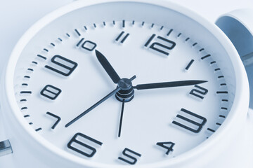 Obraz na płótnie Canvas Close-up of a white alarm clock, ten o'clock.