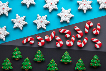Obraz na płótnie Canvas Christmas gingerbread covered with icing on a colored background, flat lay.