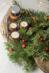 Soy candles burn in glass jars. Comfort at home. Candle in a brown jar. Scent and light. Scented handmade candle. Aroma therapy. Christmas tree and winter mood. Cozy decor. Festive garland decoration