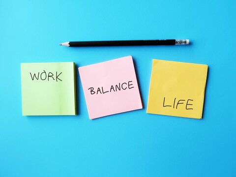 Three notes on blue background with handwritten text WORK LIFE and BALANCE , means equally prioritizing work and personal life - to maintain both professional and personal life efficiently