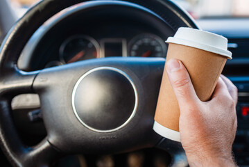 Transportation and vehicle traffic jam concept.A person drinking paper cup hot coffee in hand while...