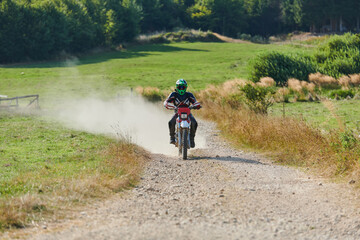 Obraz premium A professional motocross rider exhilaratingly riding a treacherous off-road forest trail on their motorcycle.
