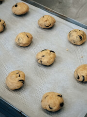 Raw cookies with chocolate on a baking sheet close-up