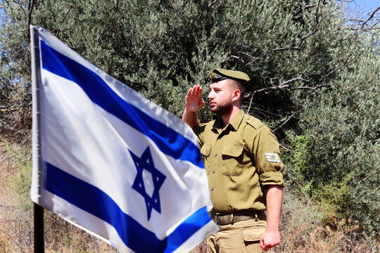 Israeli soldier salutes the Israel Flag on the holiday Yom Haatzmaut - Israel Independence Day. Photo also be used for Yom HaZikaron - Israel Memorial Day or Yom HaShoah - Holocaust Remembrance Day